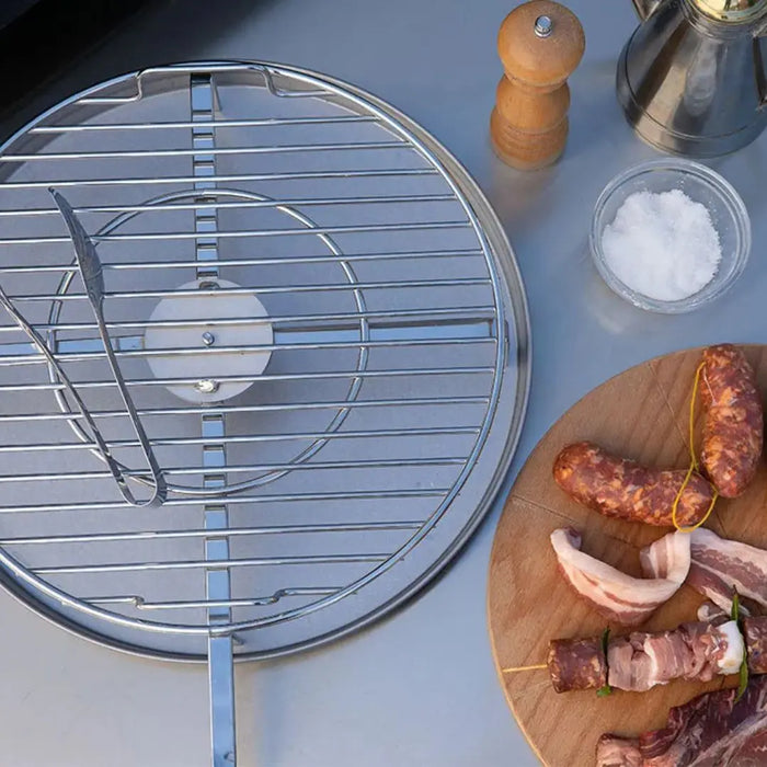 Barbecue grill grid on a table with skewered meats and seasonings.