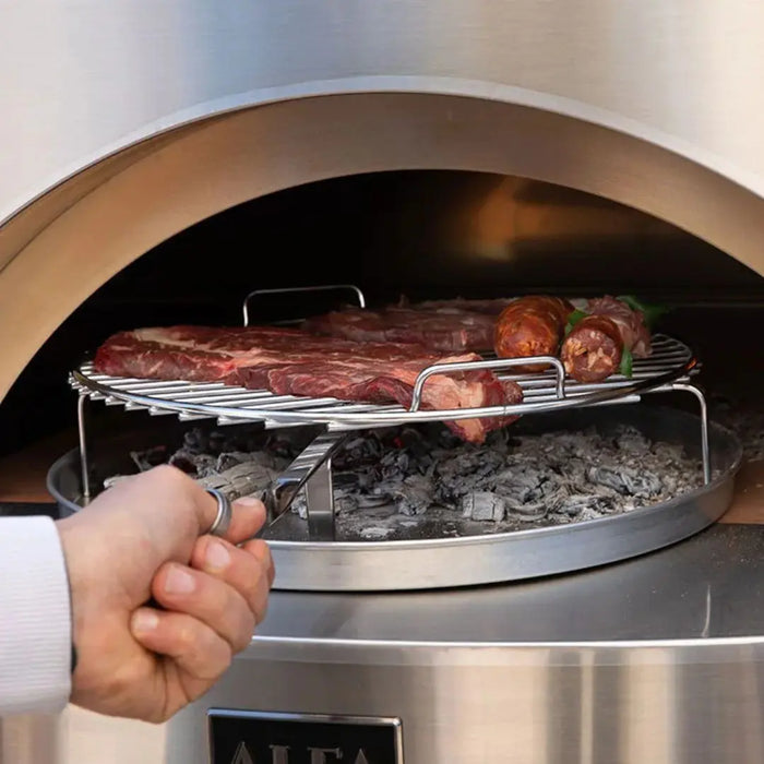 Person using tongs to handle meat on a grill inside a pizza oven.
