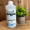 Bottle of eco3spa water conditioner on a wooden surface with a plant in the background