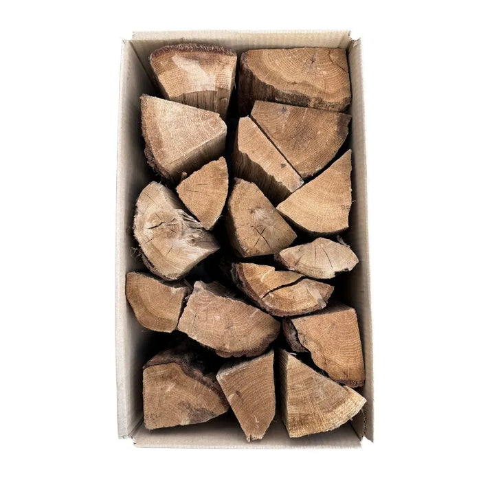 Box of oak kiln dried cooking logs for pizza oven on a white background