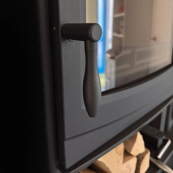 Close-up of black Woodwarm machined teardrop handle on wood burning stove